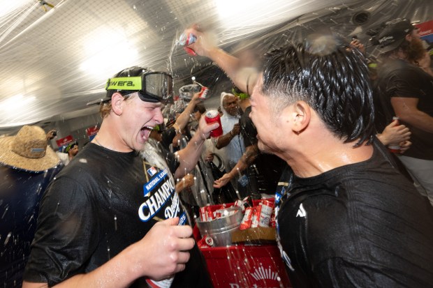 Dodgers celebrate their sweep of the NLCS with champagne after...