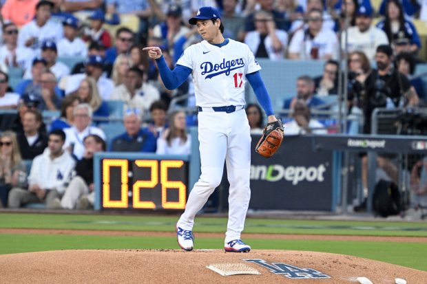 Dodgers starting pitcher Shohei Ohtani gestures to first baseman Freddie...