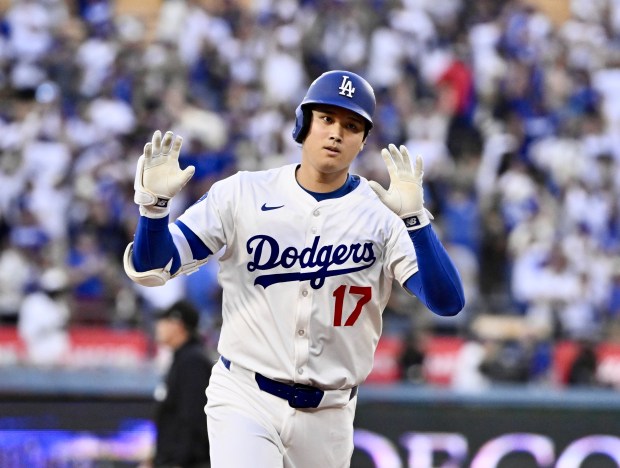 Dodgers star Shohei Ohtani gestures as he runs the bases...