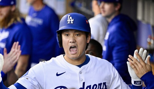 Dodgers star Shohei Ohtani celebrates in the dugout after hitting...