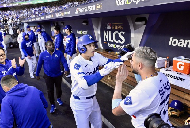 Dodgers star Shohei Ohtani, left, celebrates with teammate Miguel Rojas...