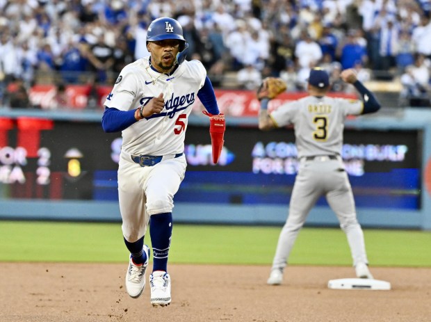 The Dodgers’ Mookie Betts advances to third base on a...