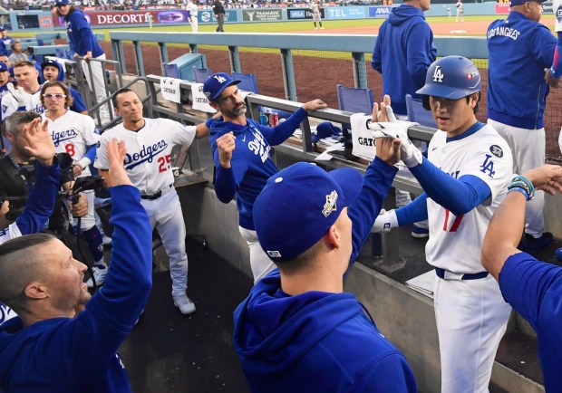 Dodgers star Shohei Ohtani, right, celebrates with teammates in the...