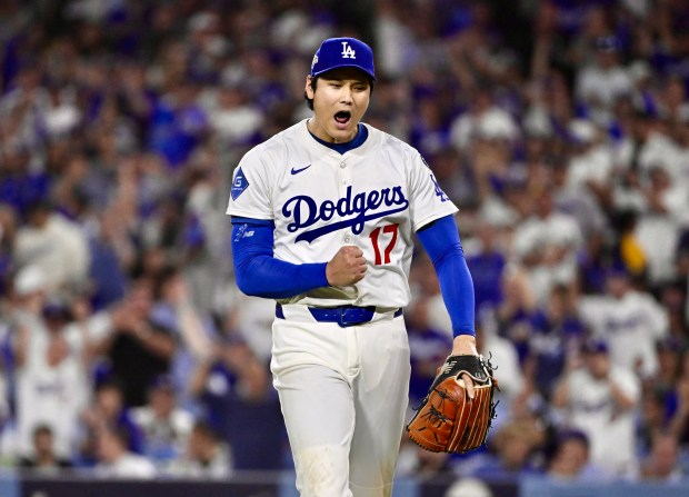 Dodgers starting pitcher Shohei Ohtani reacts after striking out the...