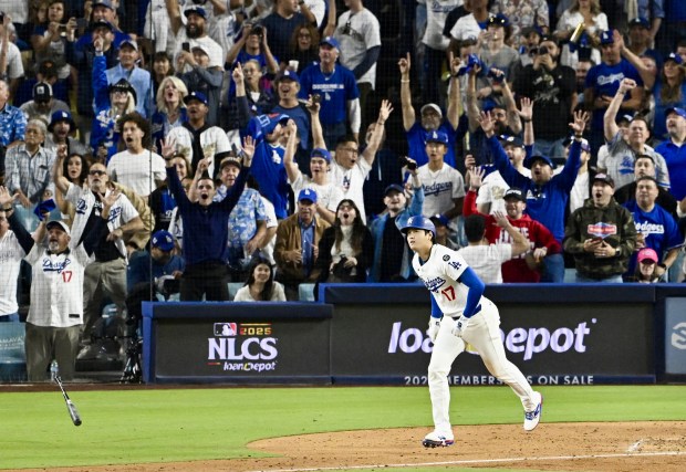 Dodgers star Shohei Ohtani begins to run the bases as...