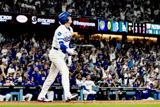 Dodgers star Shohei Ohtani tosses his bat aside as he...