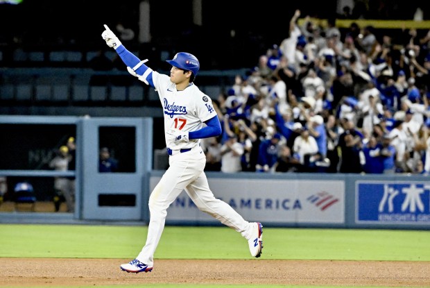 Dodgers star Shohei Ohtani gestures as he runs the bases...