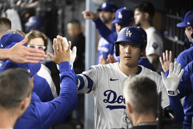 Dodgers star Shohei Ohtani celebrates in the dugout after hitting...