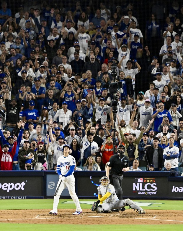 Dodgers star Shohei Ohtani watches the flight of his solo...