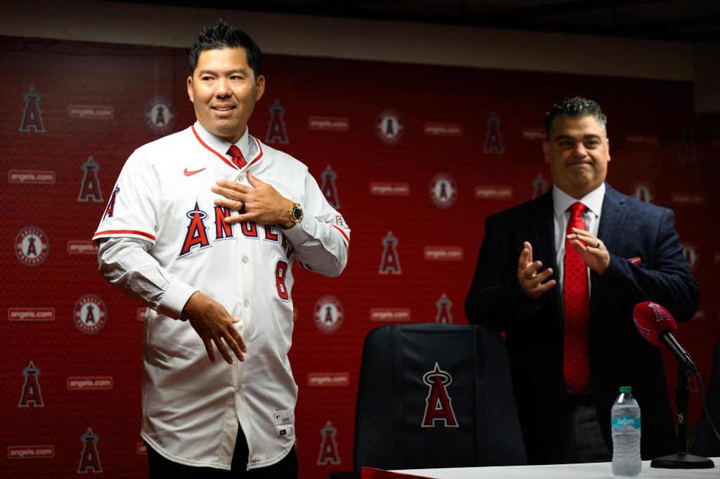 Los Angeles Angels manager Kurt Suzuki, left, receives his jersey from general manager Perry Minasian during a press conference at Angel Stadium.