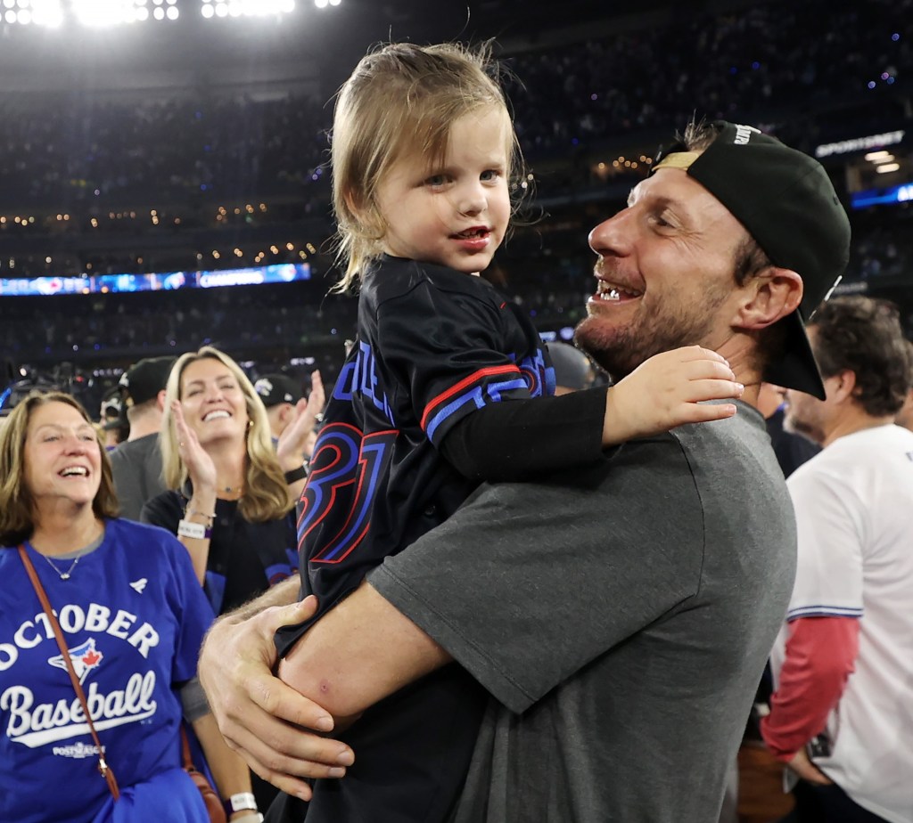 Max Scherzer hugs his daughter after the Blue Jays' ALCS series-clinching win over the Mariners in Game 7.