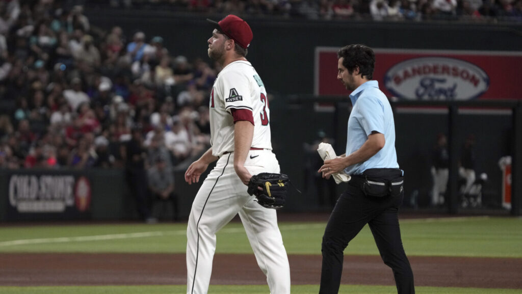 Arizona Diamondbacks pitcher Corbin Burnes, left, leaves a baseball game against the Washington Nationals in the fifth inning Sunday, June 1, 2025, in Phoenix.