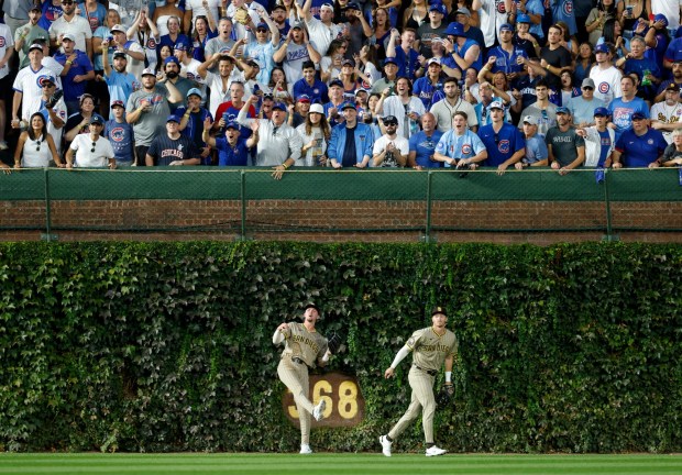 Jackson Merrill #3 of the San Diego Padres fields a double by Nico Hoerner #2 of the Chicago Cubs as Bryce Johnson #29 looks on in Game 3 of the NL Wild Card Series at Wrigley Field on Oct. 2, 2025 in Chicago, Illinois. (Photo by K.C. Alfred / The San Diego Union-Tribune)