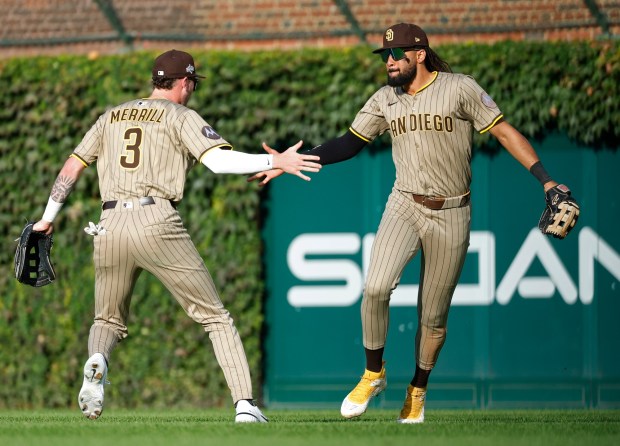 Fernando Tatis Jr. of the San Diego Padres celebrates with Jackson Merrill #3 after catching a fly ball by Nico Hoerner #2 of the Chicago Cubs in the eighth inning during Game 2 of the NL Wild Card Series at Wrigley Field on Oct. 1, 2025 in Chicago, Illinois. (Photo by K.C. Alfred / The San Diego Union-Tribune)