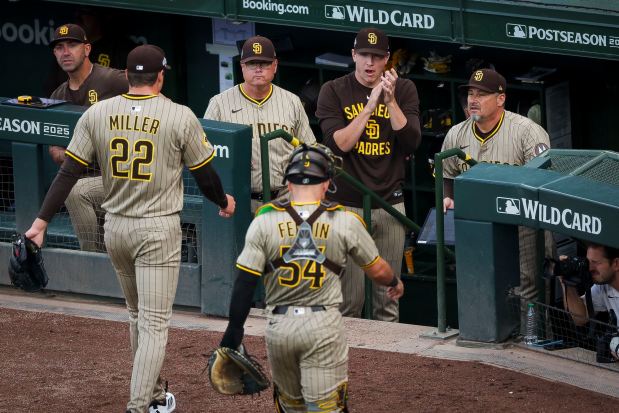 Mike Shildt #8, Nick Pivetta #27, and Ruben Niebla #57 congratulate Mason Miller #22 of the San Diego Padres as he walks into the dugout during the seventh inning against the Chicago Cubs during game two of the NL Wild Card Series at Wrigley Field on Wednesday, Oct. 1, 2025 in Chicago, Illinois. (Meg McLaughlin / The San Diego Union-Tribune)