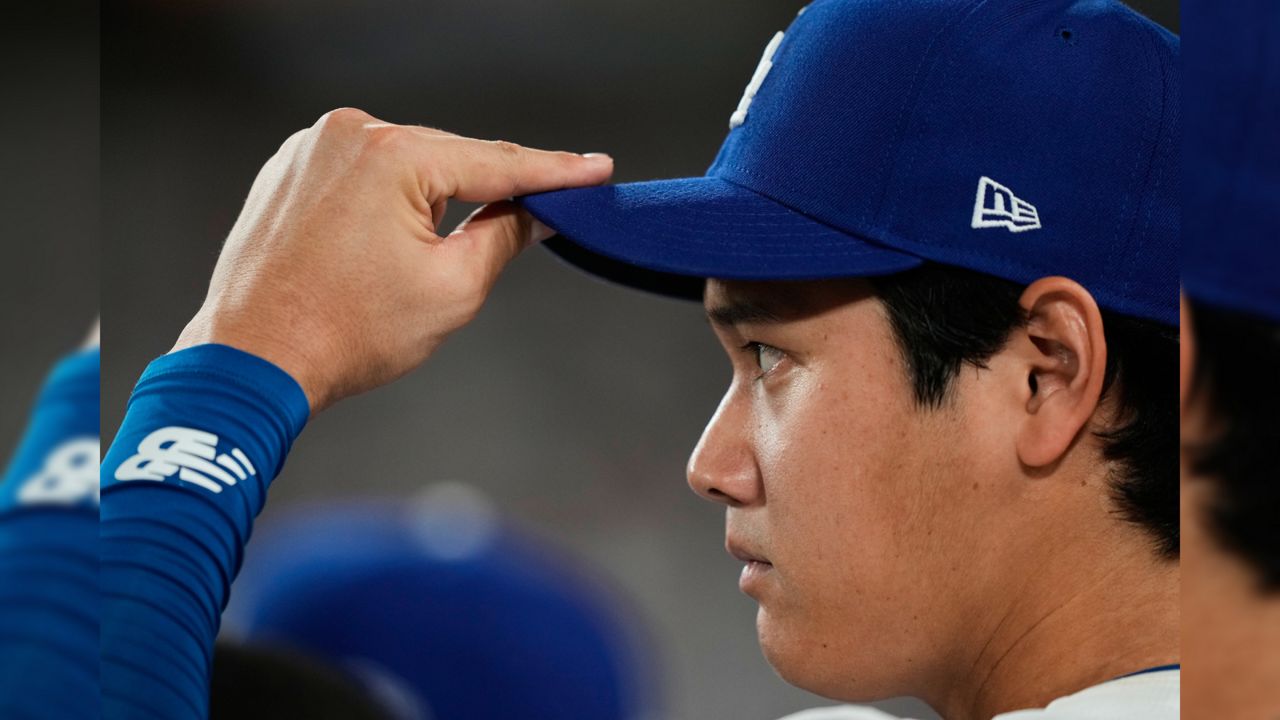 Los Angeles Dodgers' Shohei Ohtani watches from the dugout during the fifth inning in Game 1 of the National League Wild Card baseball playoff series against the Cincinnati Reds, Tuesday, Sept. 30, 2025, in Los Angeles. (AP Photo/Mark J. Terrill)