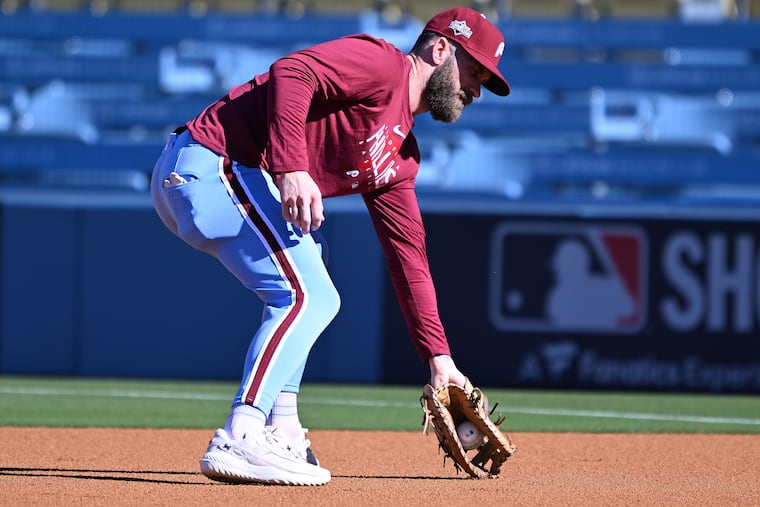 Phillies' Bryce Harper fields a ball at first base during a practice in Los Angeles ahead of Game 3 of the NLDS.
