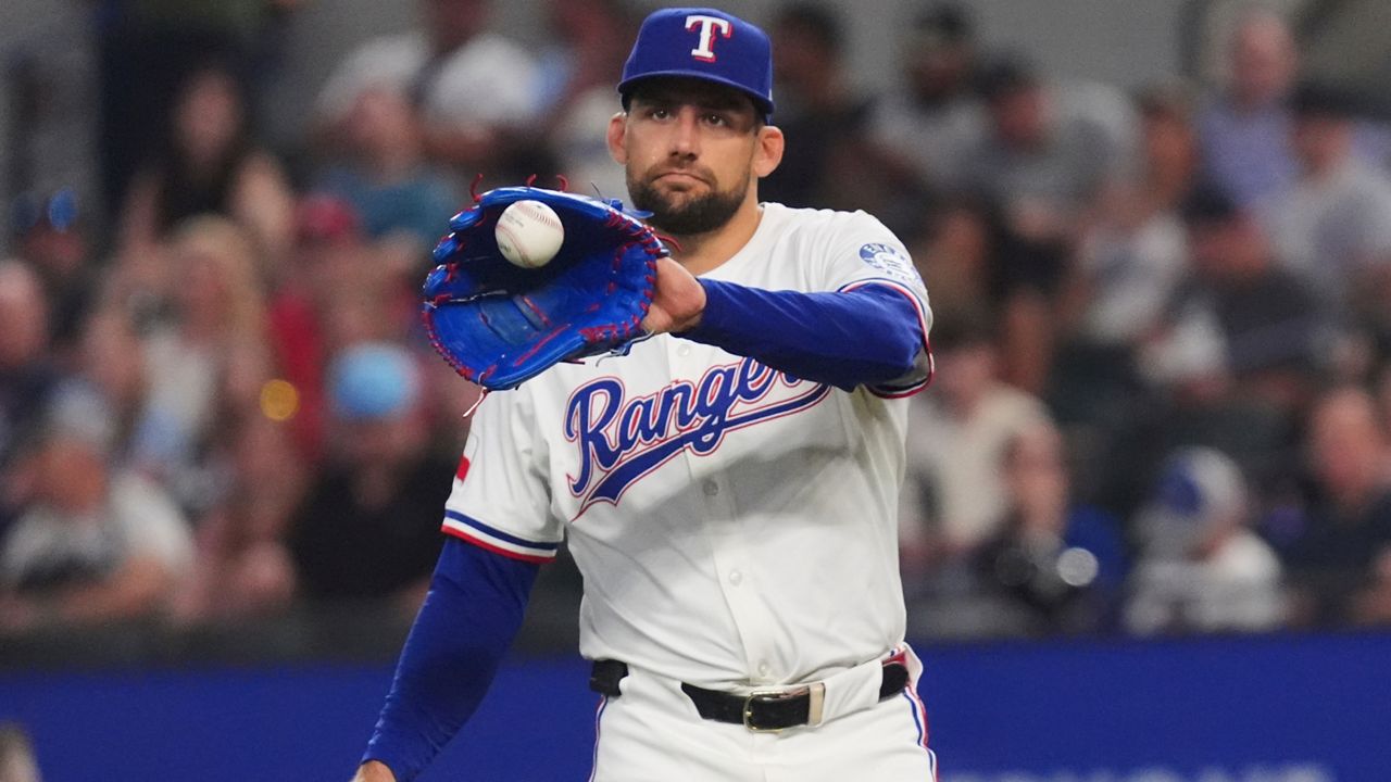 Texas Rangers starting pitcher Nathan Eovaldi reaches for the ball during the first inning of a baseball game against the New York Yankees, Tuesday, Aug. 5, 2025, in Arlington, Texas. (AP Photo/LM Otero)