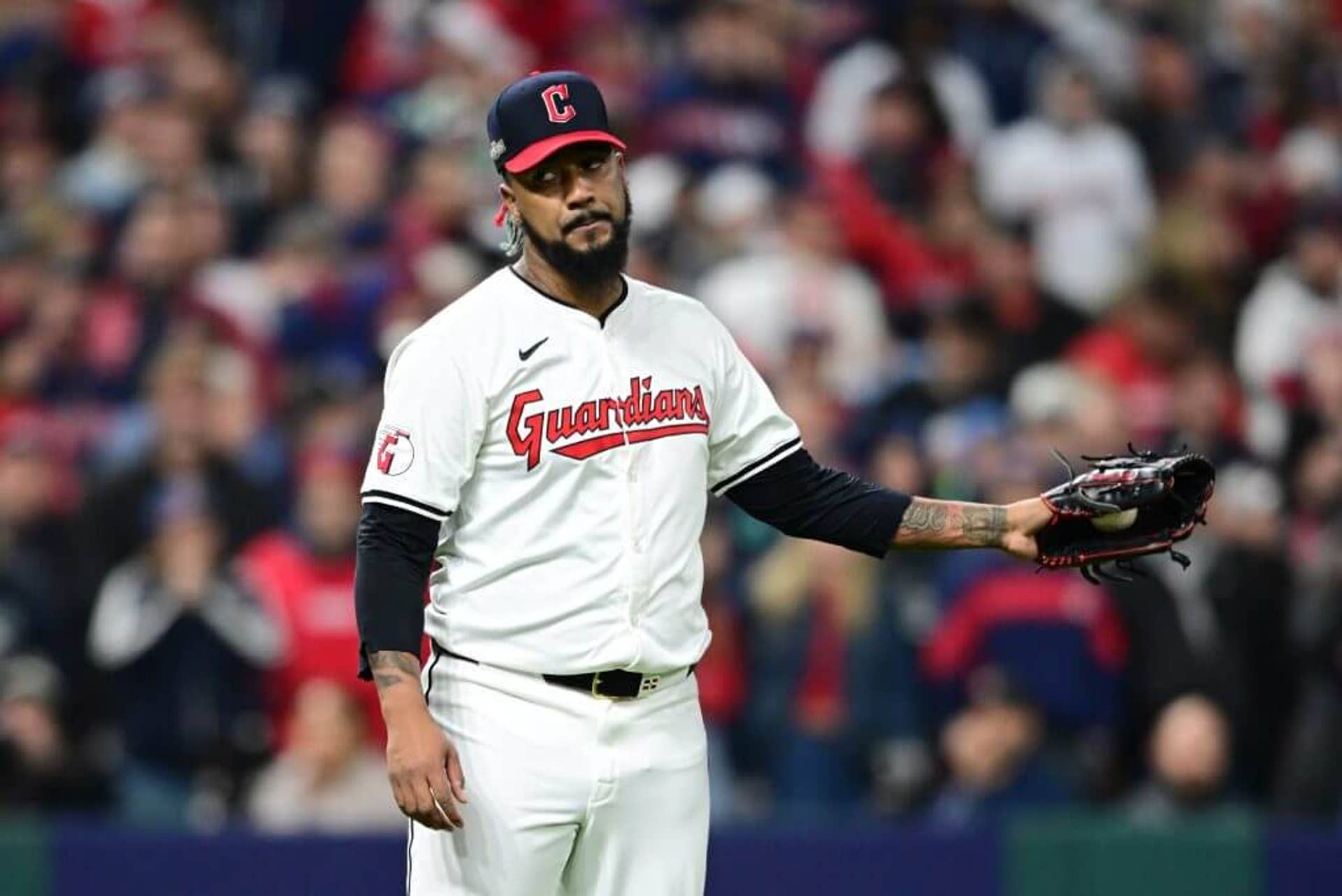 Cleveland Guardians pitcher Emmanuel Clase stands on the mound, holding his glove out to the left.