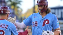 Oct 9, 2025; Los Angeles, California, USA; Philadelphia Phillies third baseman Alec Bohm (28) celebrates with Philadelphia Phillies first base coach Paco Figueroa (38) after a single in the sixth inning during game four of the NLDS round for the 2025 MLB playoffs at Dodger Stadium. Mandatory Credit: Jayne Kamin-Oncea-Imagn Images