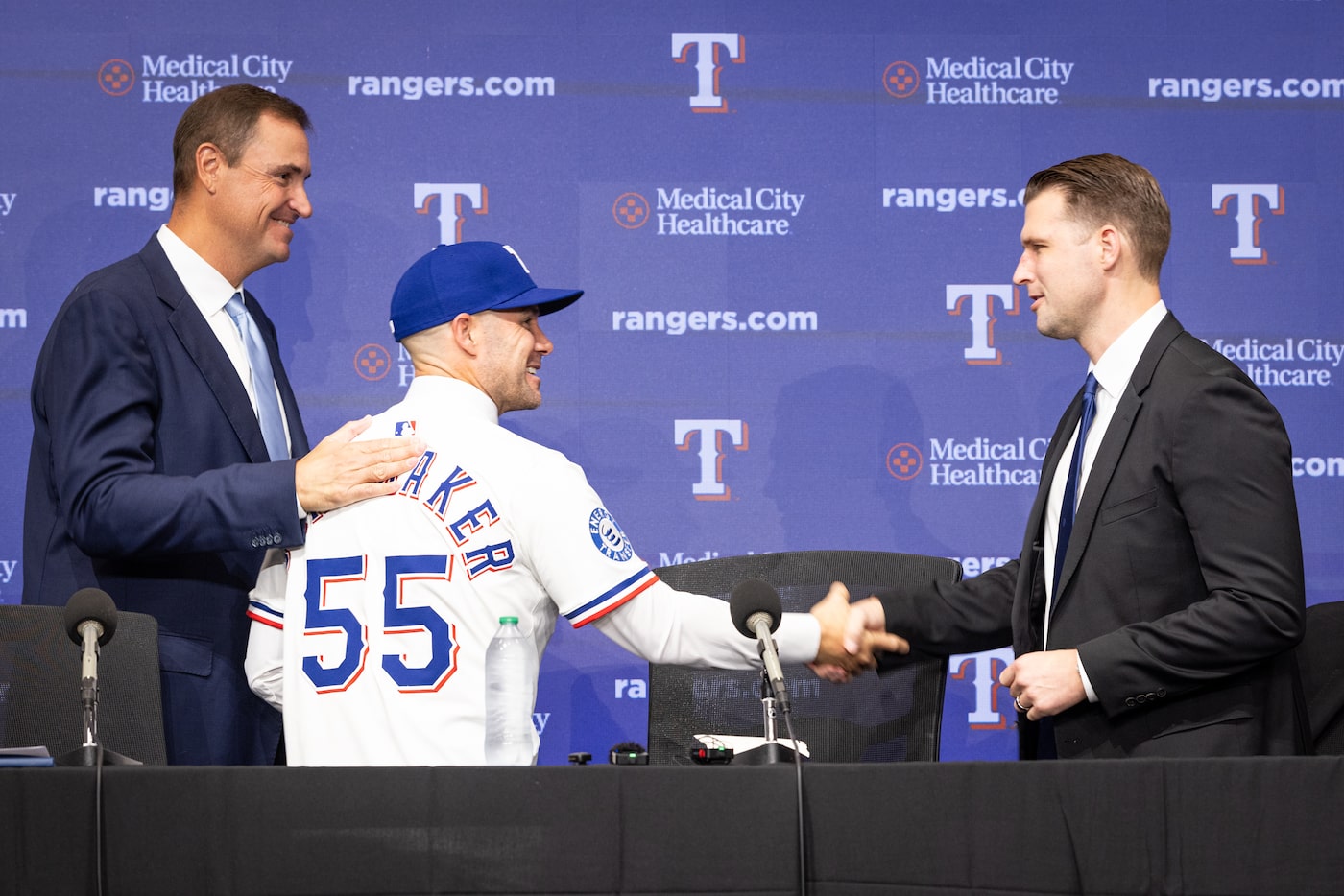 Rangers new Manager Skip Schumaker, center, shakes hands with General Manager Ross...
