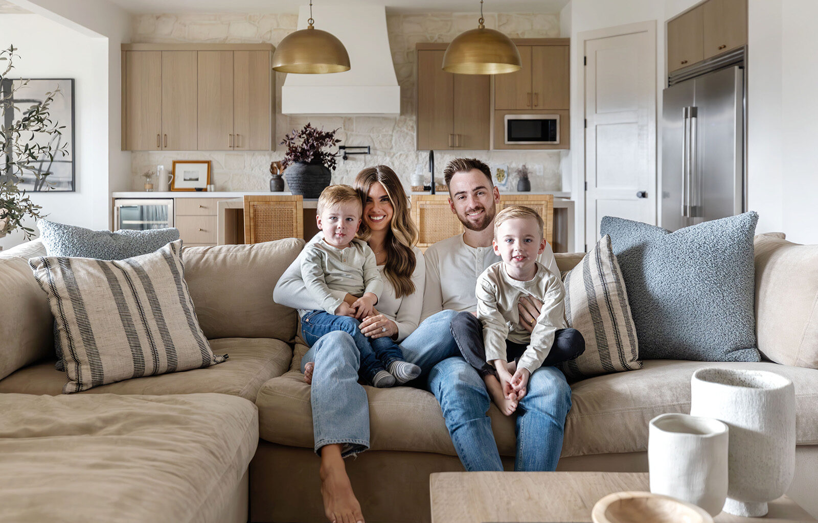 Austin and Rachel Gomber sit on the couch with their two sons