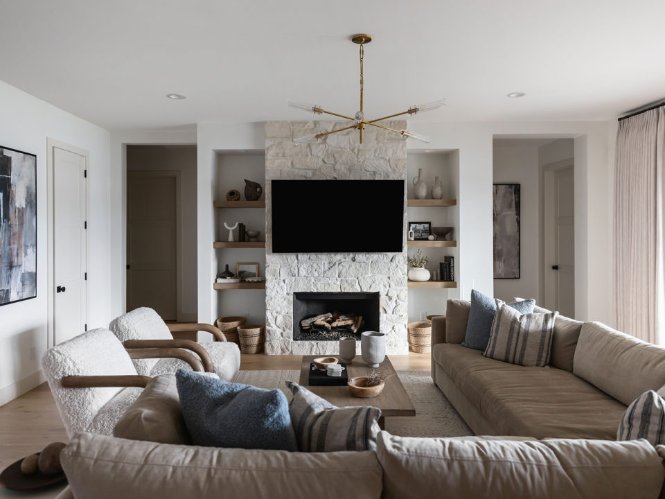 Living room with a big sectional and stone fireplace