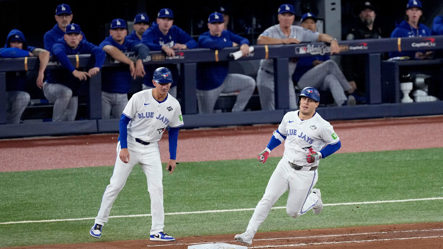 Toronto Blue Jays' Daulton Varsho runs past the Los Angeles Dodgers dugout after hitting his two ru...