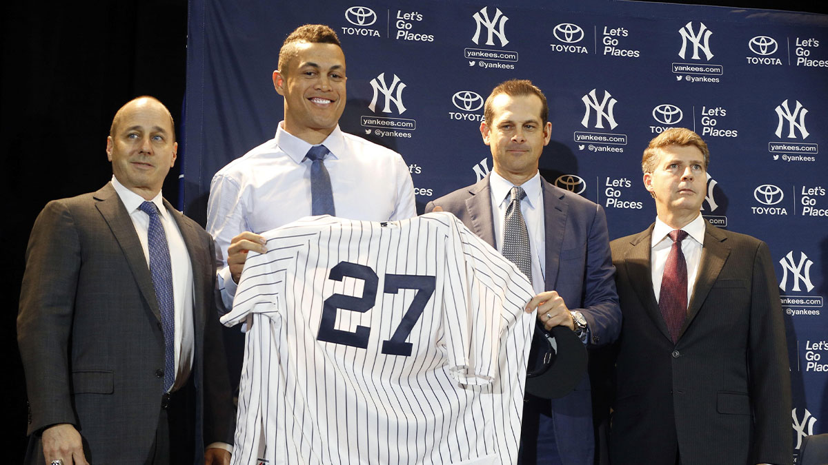 New York Yankees outfielder Giancarlo Stanton (27) is introduced with general manager Brian Cashman, manager Aaron Boone and owner Hal Steinbrenner at a press conference during the MLB winter meetings at Walt Disney World Swan and Dolphin Resort. 
