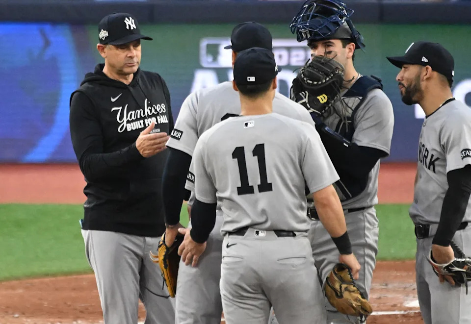 Oct 4, 2025; Toronto, Ontario, CAN; New York Yankees manager Aaron Boone (17) relieves pitcher Fernando Cruz (63) in the seventh inning against the Toronto Blue Jays during game one of the ALDS round for the 2025 MLB playoffs at Rogers Centre. Mandatory Credit: Dan Hamilton-Imagn Images