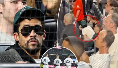 Bad Bunny sits during God Bless America at Yankee Stadium during MLB Playoff game