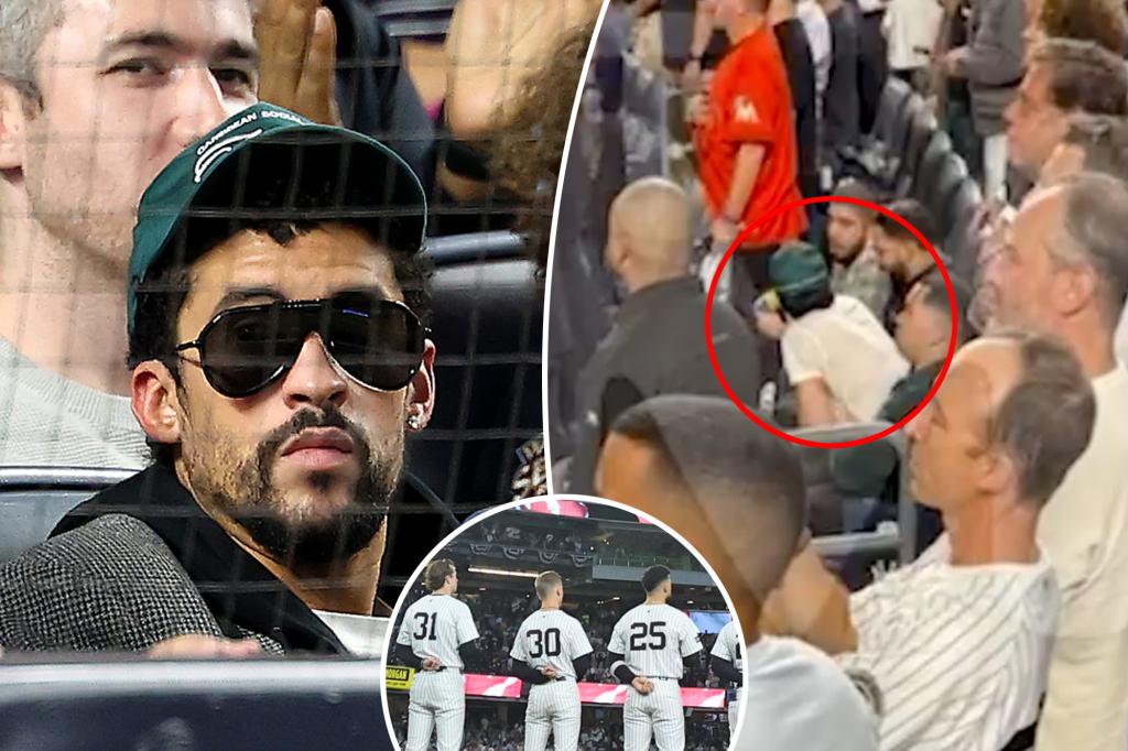 Bad Bunny sits during God Bless America at Yankee Stadium during MLB Playoff game