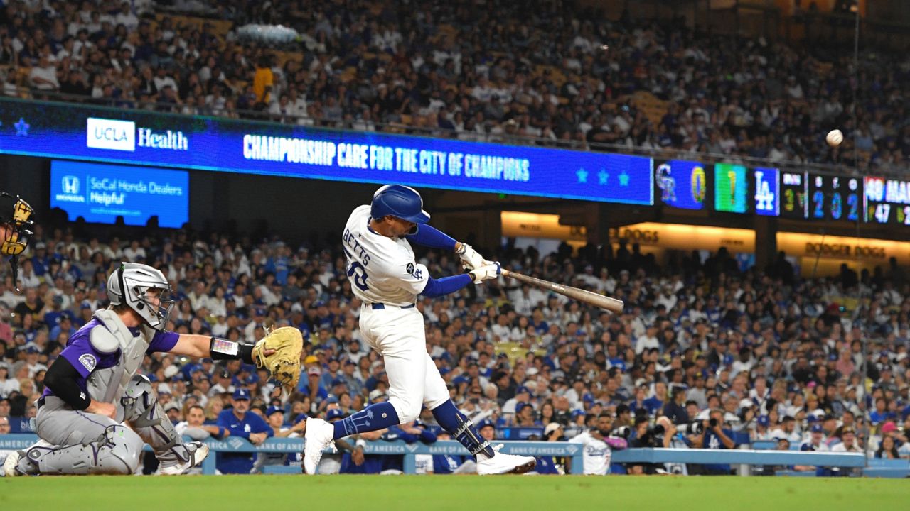Los Angeles Dodgers' Mookie Betts right, hits a two-run home run as Colorado Rockies catcher Hunter Goodman watches during the third inning of a baseball game Tuesday in LA. (AP Photo/Mark J. Terrill)