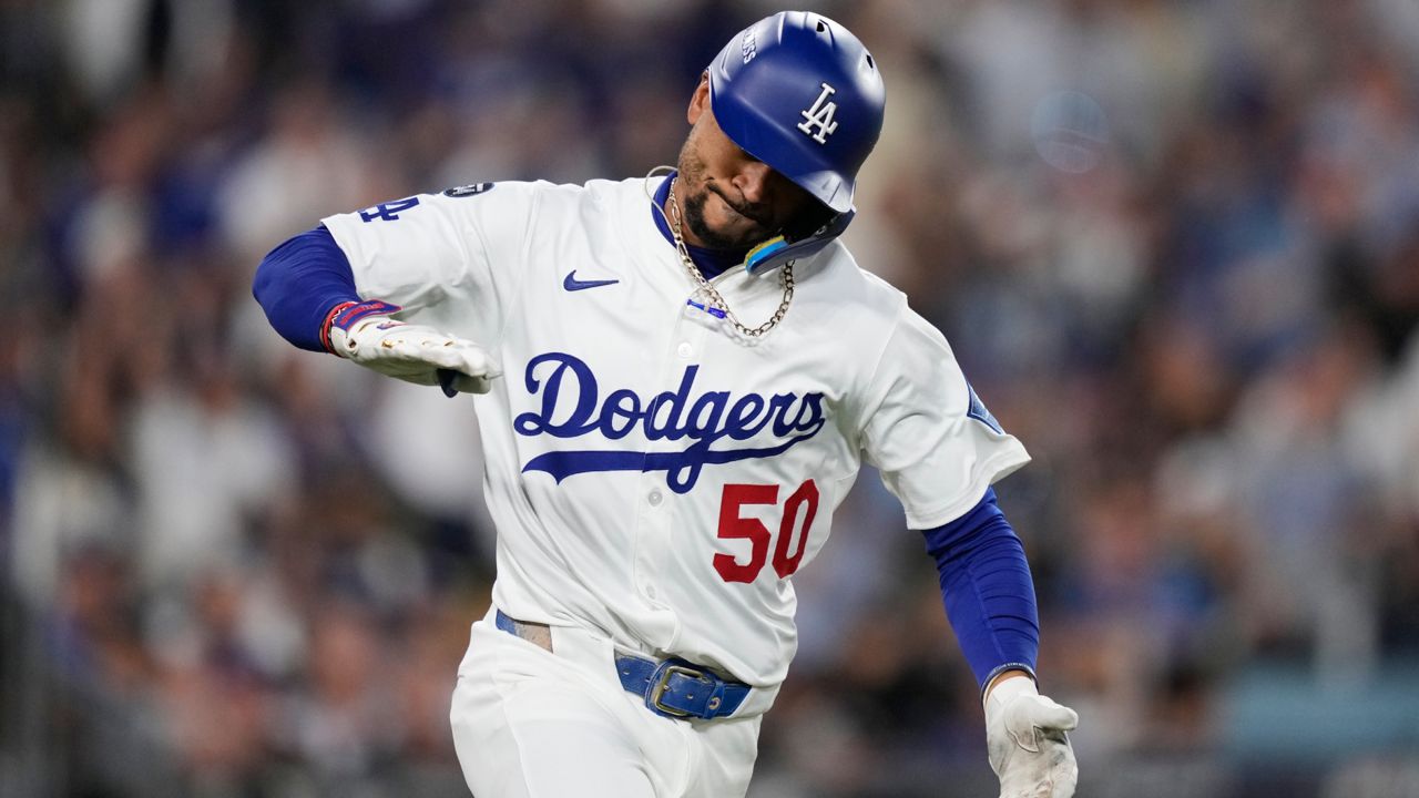 Los Angeles Dodgers' Mookie Betts reacts as he drives in a run with a single during the third inning in Game 2 of the National League Wild Card baseball playoff series against the Cincinnati Reds on Wednesday in LA. (AP Photo/Mark J. Terrill)