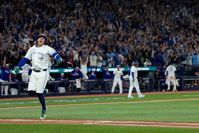 Toronto Blue Jays&apos; George Springer reacts after hitting a three run home run against the Seattle Mariners during the seventh inning in Game 7 of baseball&apos;s American League Championship Series.