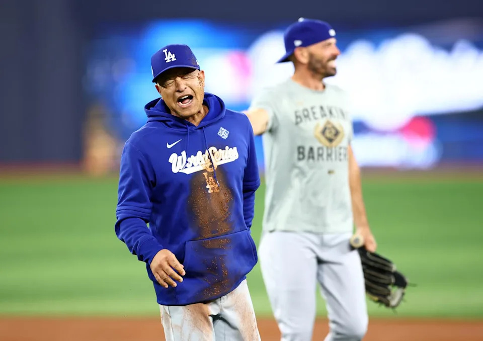 Dodgers manager Dave Roberts reacts after falling while challenging Hyeseong Kim to a race.