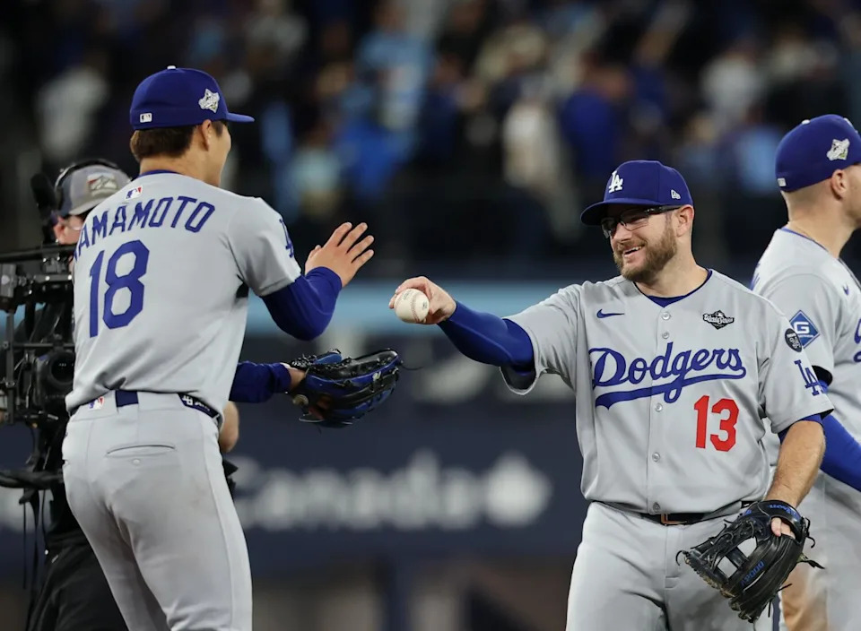Dodgers pitcher Yoshinobu Yamamoto is given the game ball by third baseman Max Muncy after pitching a complete game Saturday.