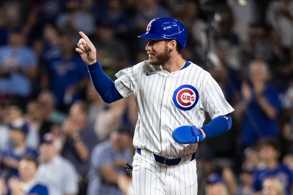 Cody Bellinger #24 of the Chicago Cubs points towards the field after scoring a run