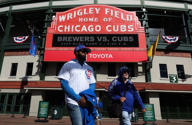 Fans walk past the marquee before the NLDS Game 3...