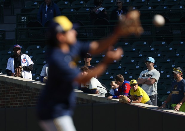 Fans watch Brewers players warm up for the NLDS Game 3 against the Cubs at Wrigley Field on Oct. 8, 2025, in Chicago. (John J. Kim/Chicago Tribune)