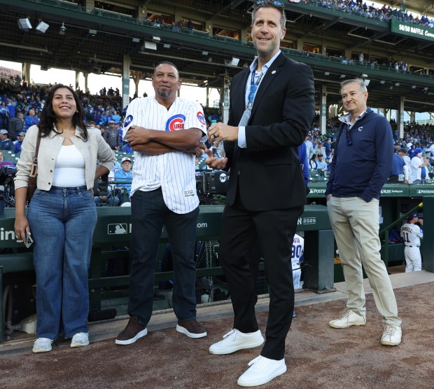 Former Cubs pitcher Carlos Zambrano, center left, waits to throw the ceremonial first pitch for the NLDS Game 3 against the Brewers at Wrigley Field on Oct. 8, 2025, in Chicago. On the right is Cubs Chairman Tom Ricketts. (John J. Kim/Chicago Tribune)