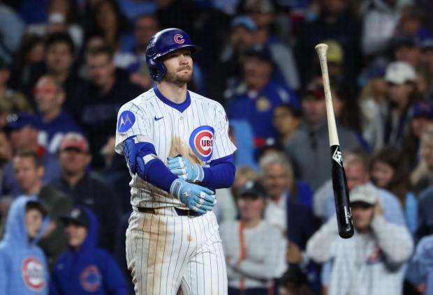 Cubs left fielder Ian Happ tosses his bat after striking...