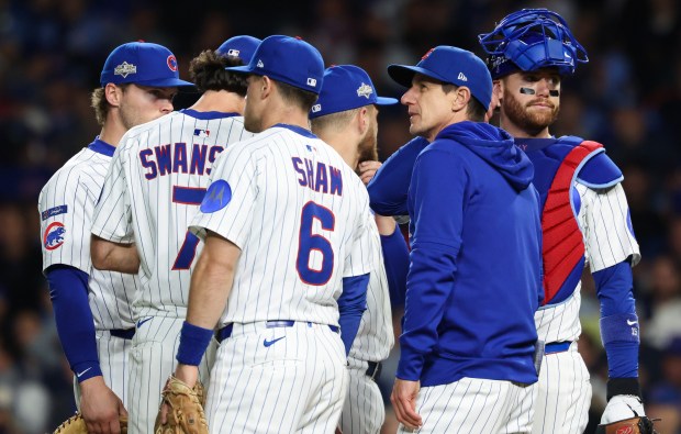 Cubs manager Craig Counsell and players wait during a pitching...