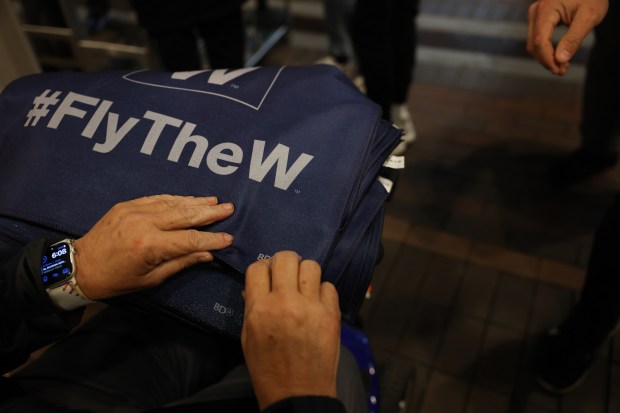 Rally towels are handed to entrants for Game 4 of the NLCS between the Cubs and Brewers at Wrigley Field on Oct. 9, 2025, in Chicago. (John J. Kim/Chicago Tribune)