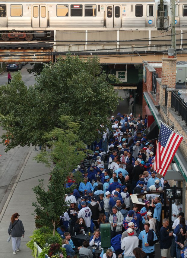 A CTA train passes as fans gather at a pub before Game 4 of the NLCS between the Cubs and Brewers at Wrigley Field on Oct. 9, 2025, in Chicago. (John J. Kim/Chicago Tribune)