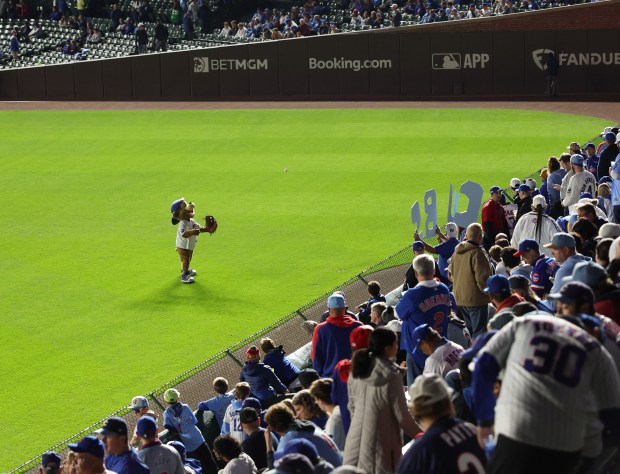 Cubs mascot Clark plays catch with a fan before Game 4 of the NLCS between the Cubs and Brewers at Wrigley Field on Oct. 9, 2025, in Chicago. (John J. Kim/Chicago Tribune)