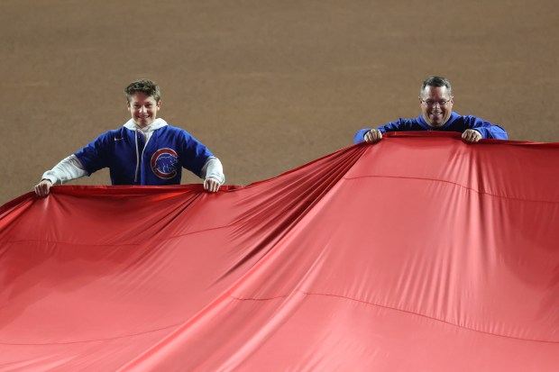 Fans hold an oversized U.S. flag during the national anthem before Game 4 of the NLCS between the Cubs and Brewers at Wrigley Field on Oct. 9, 2025, in Chicago. (John J. Kim/Chicago Tribune)