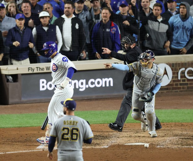 The home plate umpire and Brewers catcher William Contreras point...