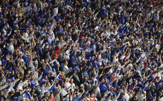 Fans sing "Take Me Out to the Ball Game" during the seventh-inning stretch of Game 4 of the NLCS between the Cubs and Brewers on Oct. 9, 2025, at Wrigley Field. (John J. Kim/Chicago Tribune)