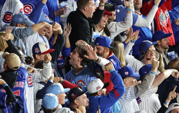 Fans cheer after Cubs first baseman Michael Busch hits a...